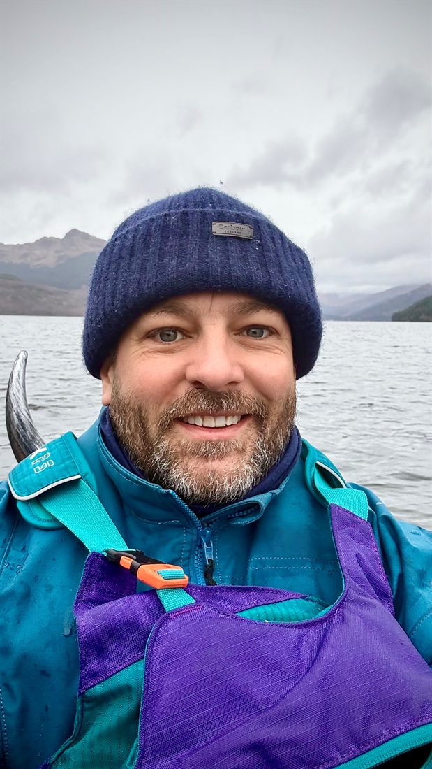 Packraft with a viking helmet on the shore.